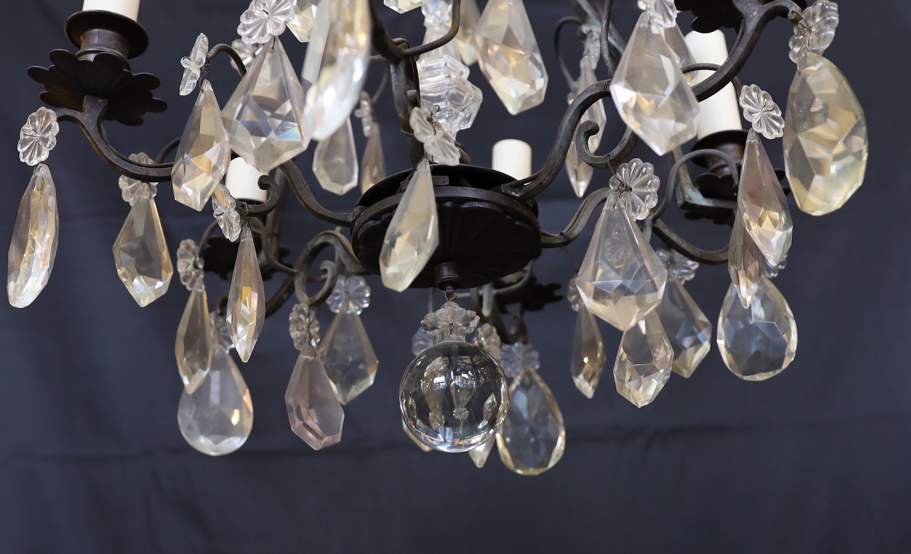 An early 20th century French bronze and cut glass six light chandelier hung with tear shaped and faceted drops, height 63cm. width 42cm